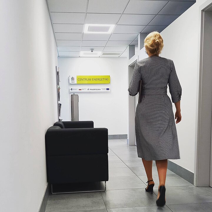 kobieta idąca korytarzem w biurze Centrum Energetyki