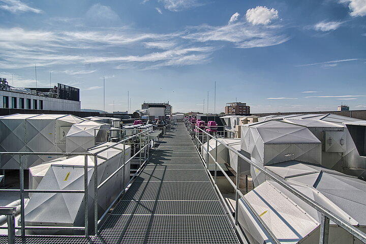 widok dachu z instalacją wentylacyjną w słoneczny dzień, niebieskie niebo z białymi chmurami,